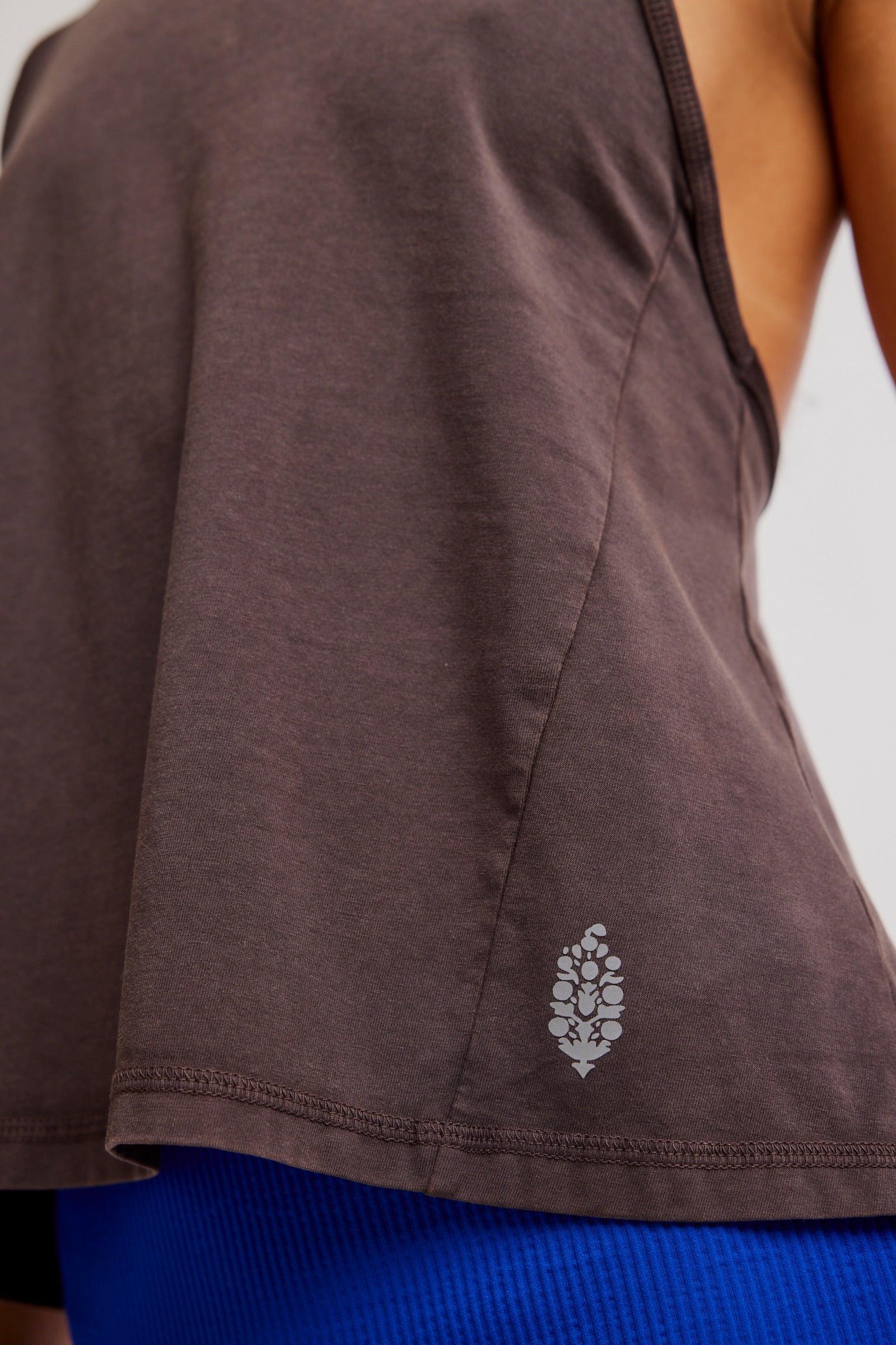 Brown sleeveless top with a floral pattern on a white background