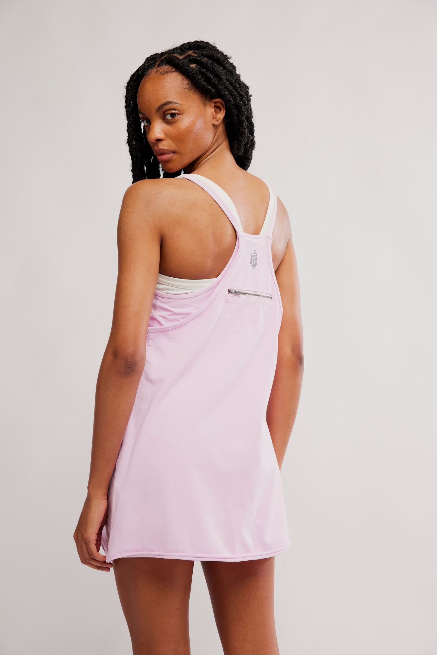 model wearing pink athletic mini dress facing backwards