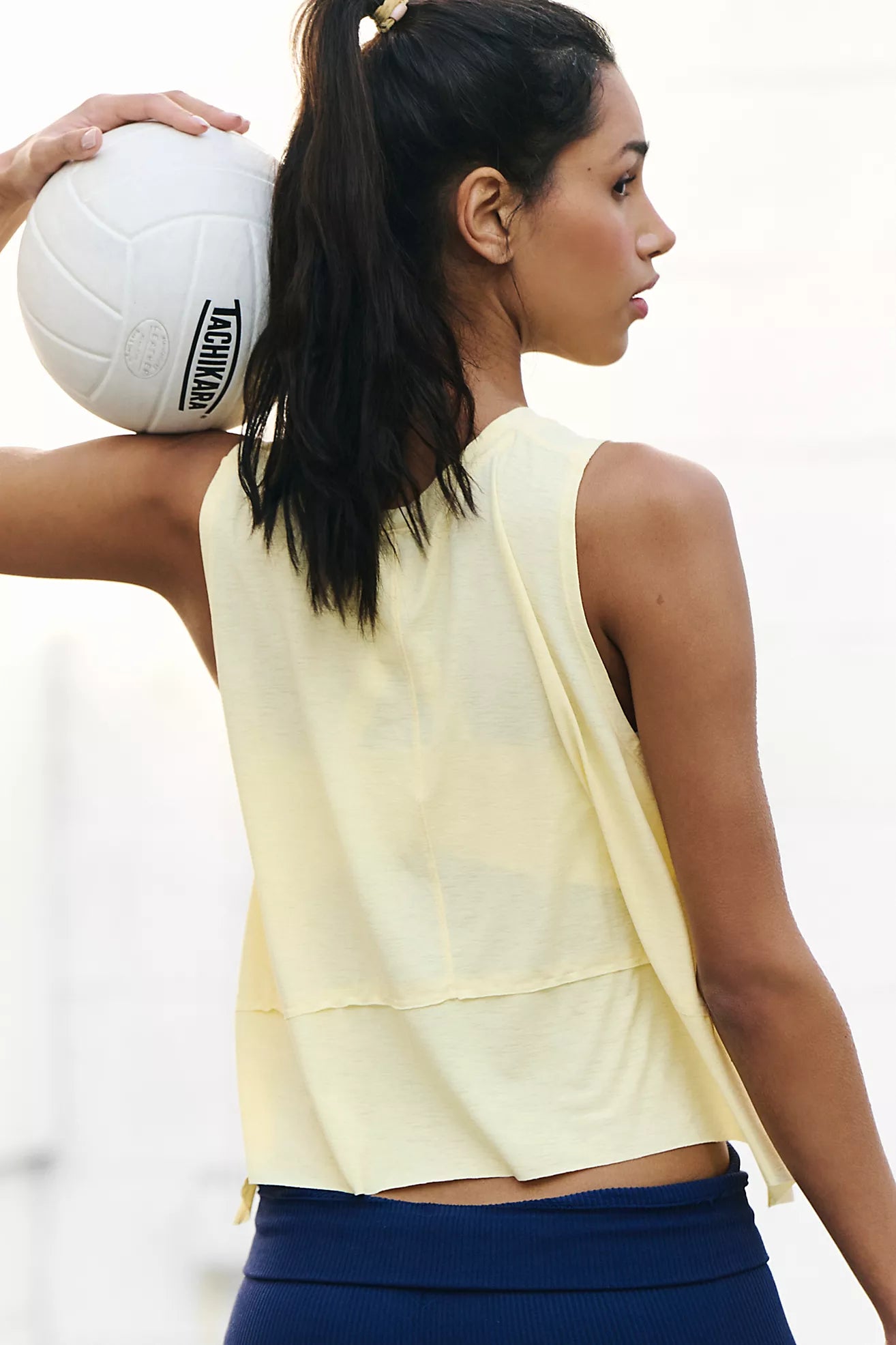model facing backwards wearing yellow tank