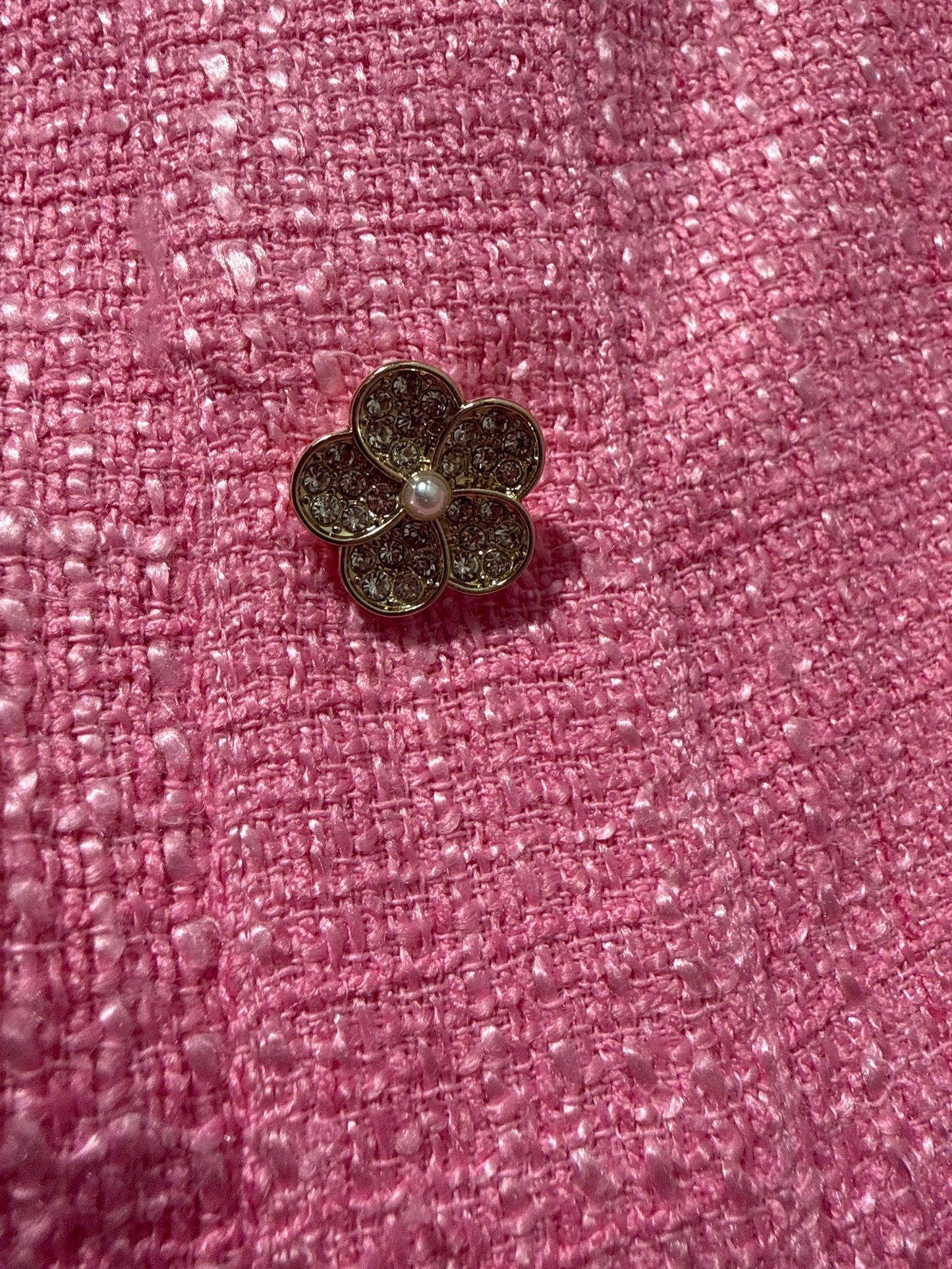 Flower-shaped button on a pink textured background