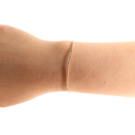 BOUTIQUE BEADED BLONDES 2MM GOLD BRACELET ON ARM