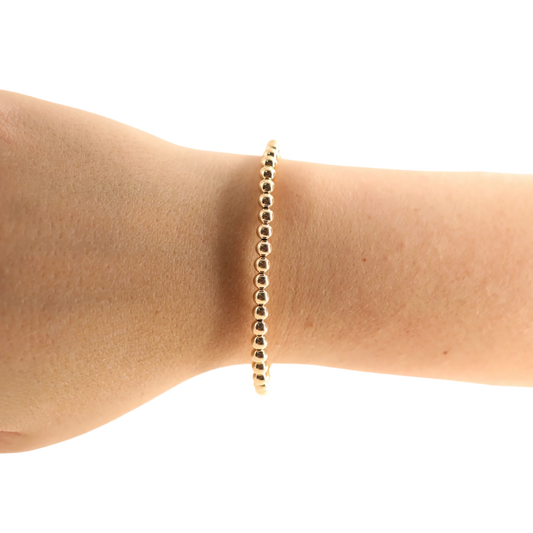 BOUTIQUE BEADED BLONDES 4MM GOLD BRACELET ON ARM