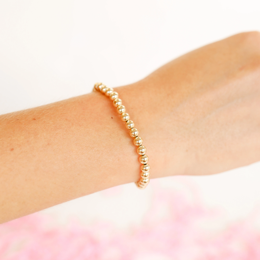 BOUTIQUE BEADED BLONDES 5MM GOLD BRACELET ON ARM