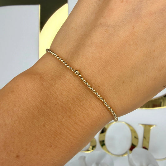 Beaded Blondes 2mm Gold Bracelet shown as a delicate single strand of gold beads on a wrist.