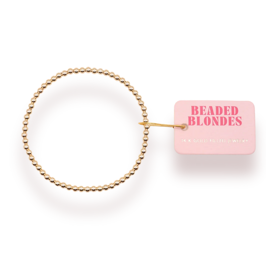 Beaded Blondes 3mm Gold Bracelet beside a pink jewelry tag.