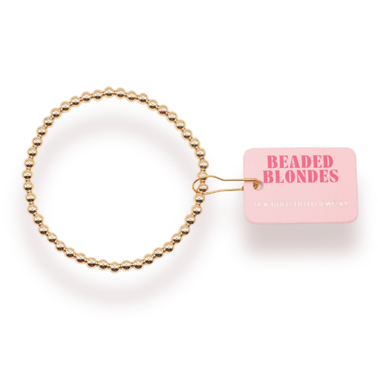 Beaded Blondes 4mm Gold Bracelet beside a pink jewelry tag.