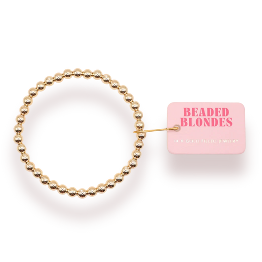 Beaded Blondes 5mm Gold Bracelet beside a pink jewelry tag.