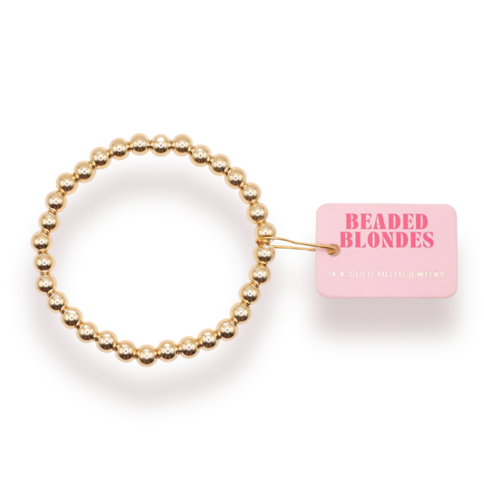 Beaded Blondes 6mm Gold Bracelet beside a pink jewelry tag.
