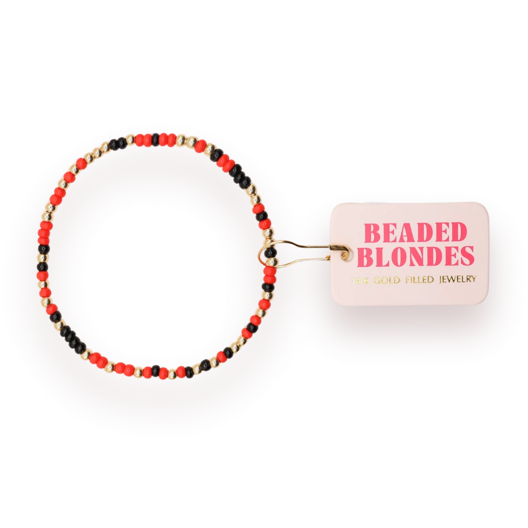 Beaded Blondes Bright Red and Black Sprinkle Bracelet with red, black and gold-tone beads beside a pink tag.
