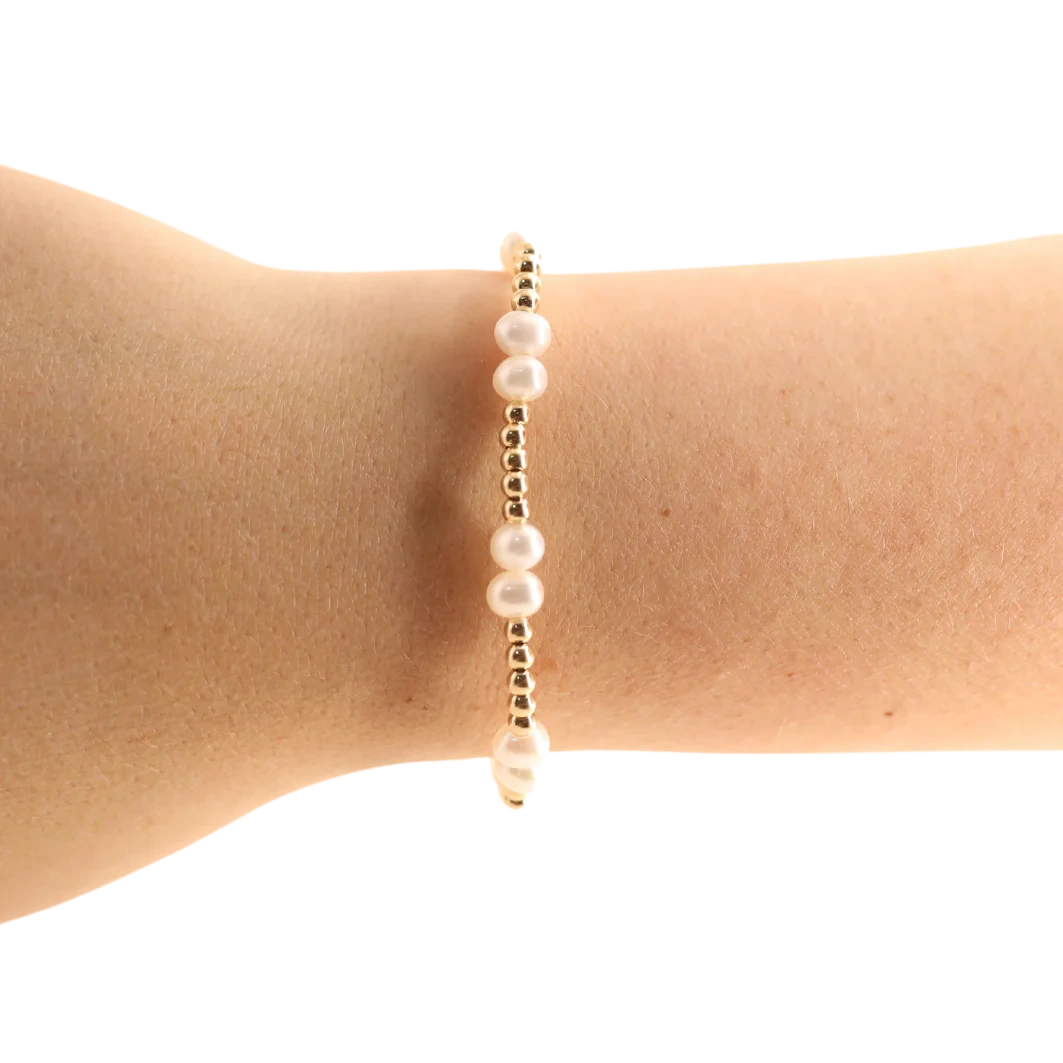Beaded Blondes Coastal Pearl Bracelet in Gold worn alone on a wrist, showing its white pearls and gold bead pattern.