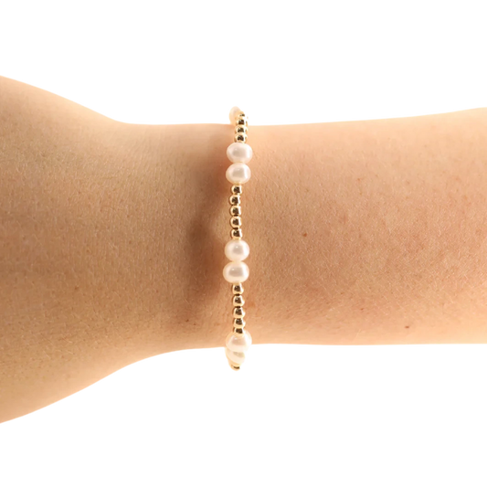 Beaded Blondes Coastal Pearl Bracelet in Gold worn alone on a wrist, showing its white pearls and gold bead pattern.