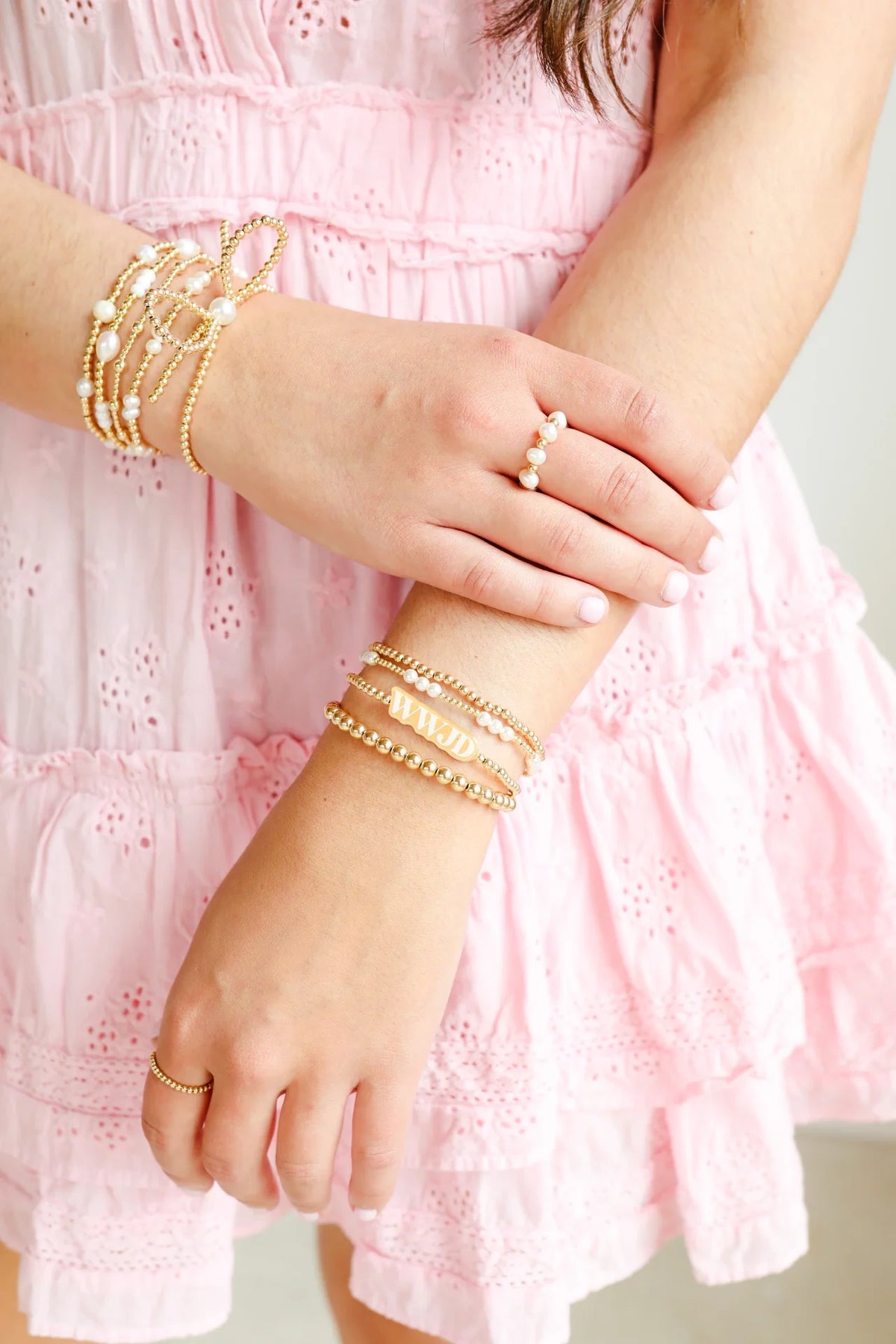 Beaded Blondes pearl rings and gold bracelet stacks styled with a pink ruffled dress.