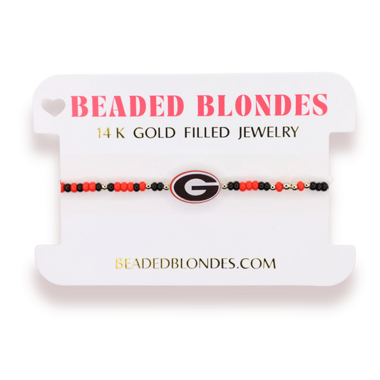 Beaded Blondes Georgia Logo Bracelet on Color displayed on a pink jewelry card.
