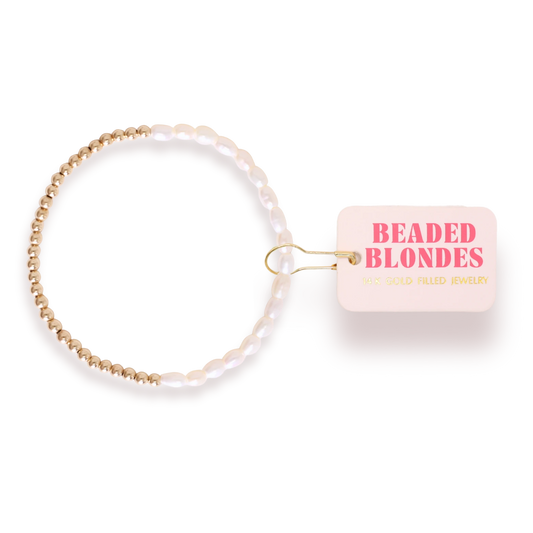 Beaded Blondes Hannah Pearl Bracelet in Gold beside a pink jewelry tag.