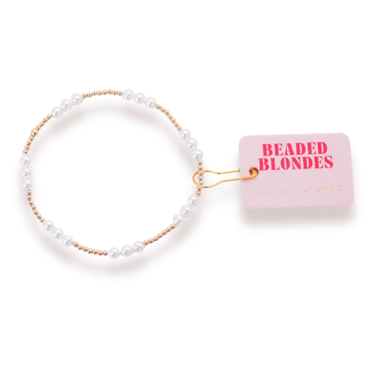 Beaded Blondes ILY Pearl Bracelet in Gold with a white pearl accent and small gold beads beside a brand tag.