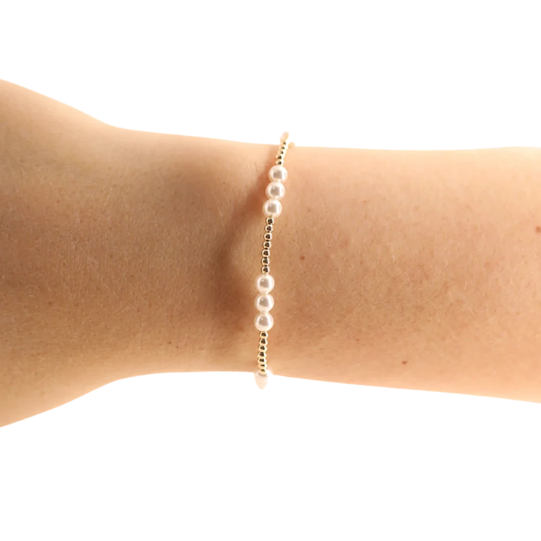 Beaded Blondes ILY Pearl Bracelet in Gold worn alone, showing three white pearl accents along a delicate gold band.