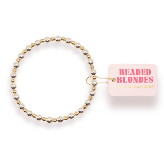 Beaded Blondes Katy Bracelet in Silver with Gold beside a pink jewelry tag.