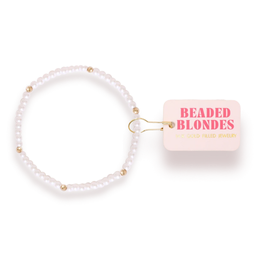 Beaded Blondes Lily Pearl Bracelet in Gold beside a pink jewelry tag.