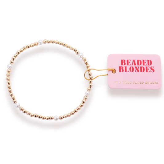 Beaded Blondes Madi Pearl Bracelet in Gold beside a pink jewelry tag.