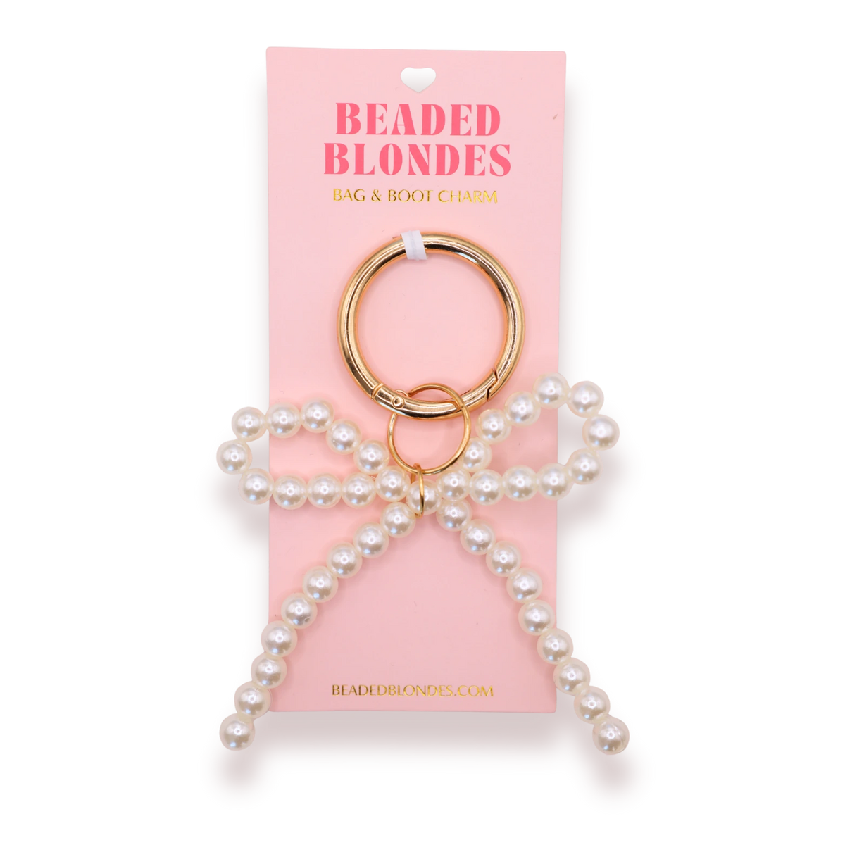 Beaded Blondes Pearl Bow Bag and Boot Charm with a white beaded bow and gold-tone clip ring on a pink display card.