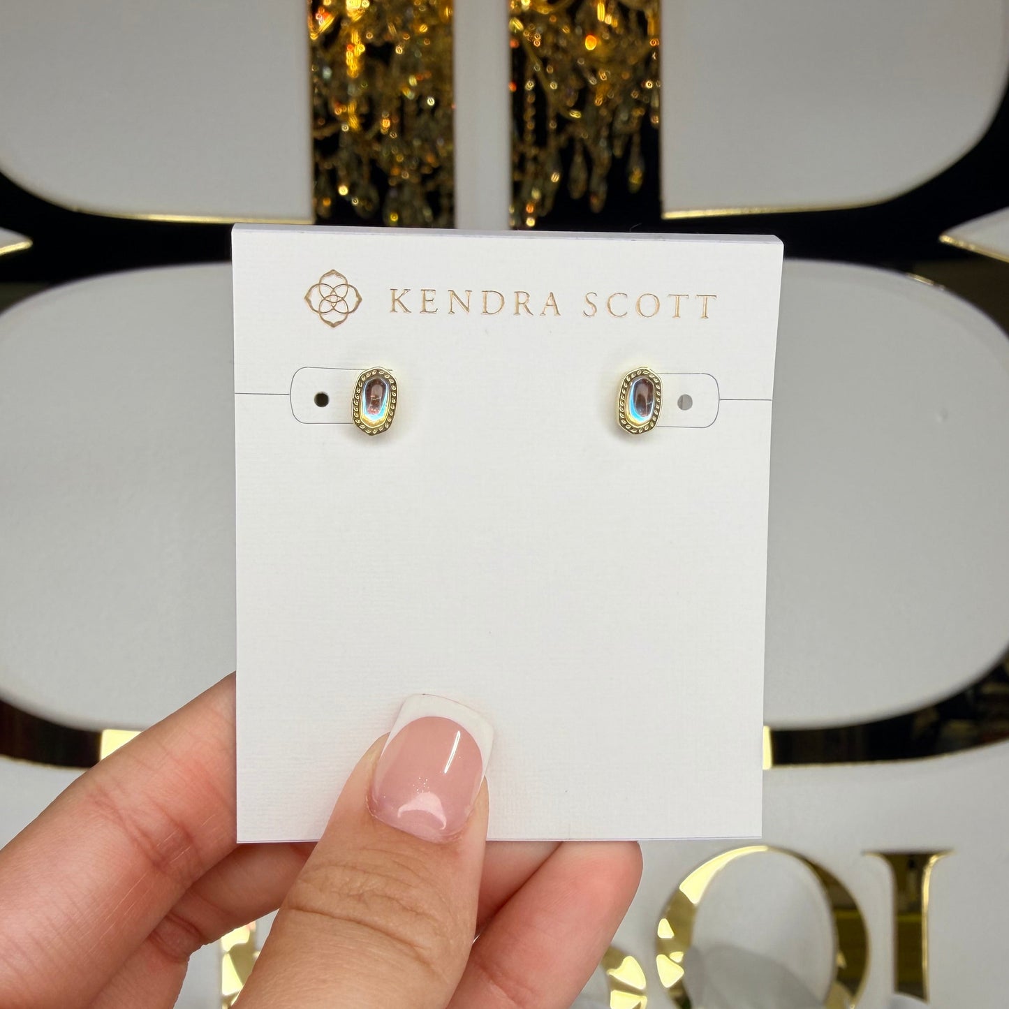 Hand holding a card with earrings on a decorative background