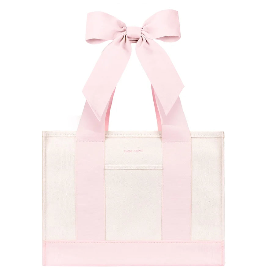 A Case-Mate Bow Canvas Tote Bag Ballet Pink with wide pink shoulder straps forming a large bow at the top, shown on a plain white background.