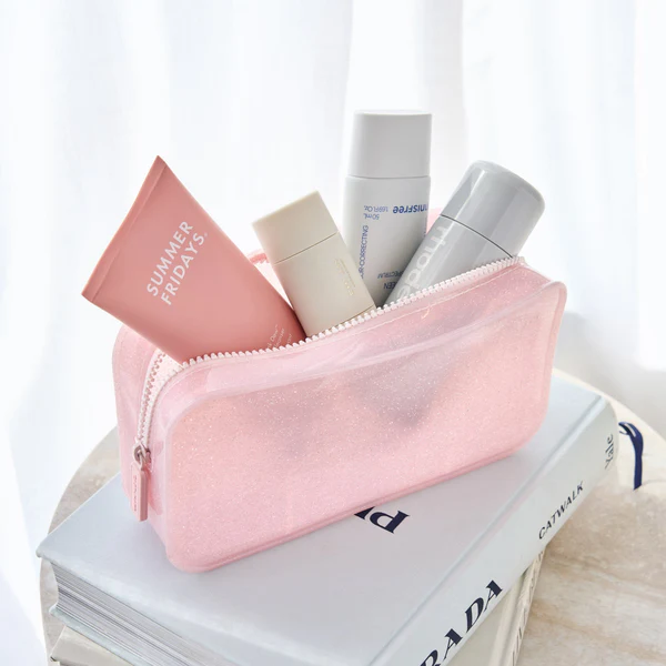 Pink Casemate glitter makeup bag with zipper closure with products inside