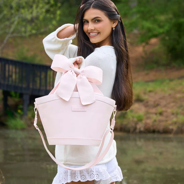 women holding Casemate pink mini cooler with bow strap