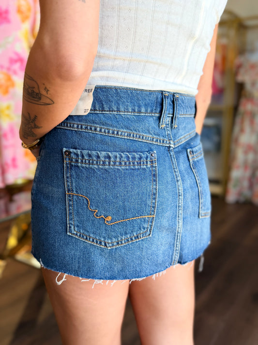 model wearing medium wash denim skirt from the back