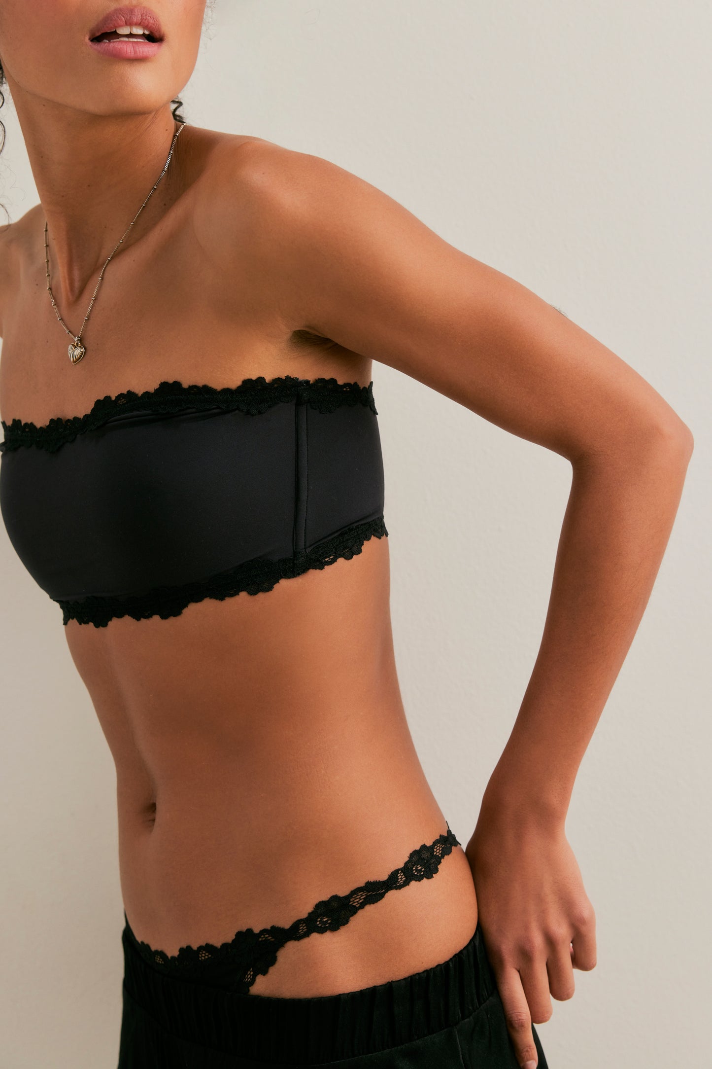 Black strapless top and underwear set worn by a model on a plain background