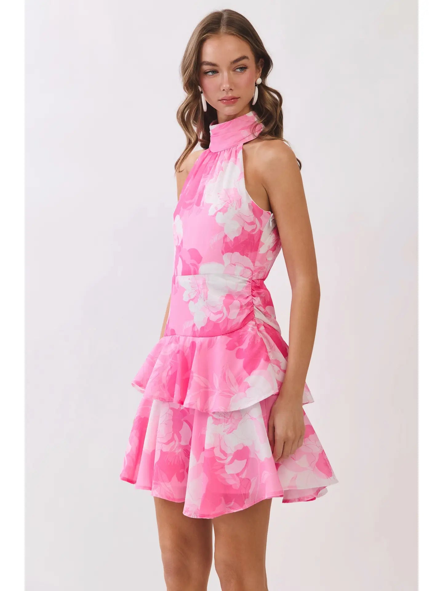Woman wearing a pink and white floral dress on a white background