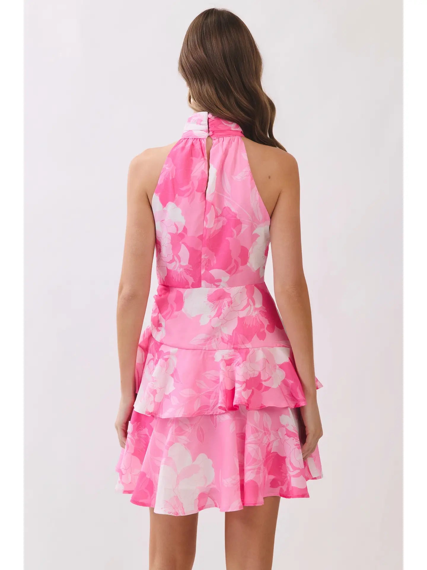 Woman wearing a pink floral dress on a white background