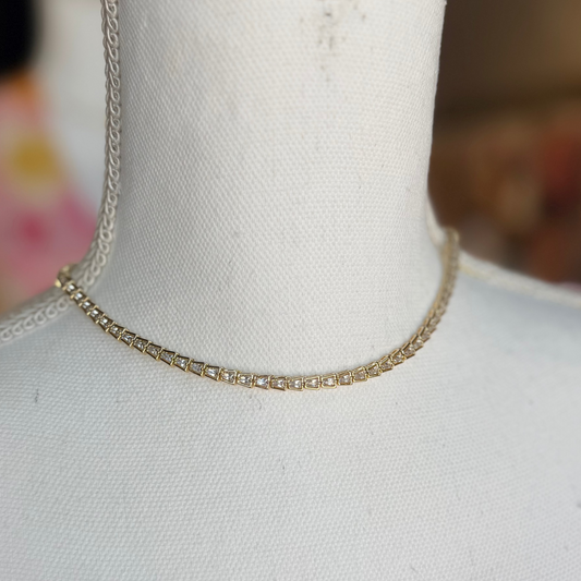 Gold chain necklace on a mannequin with a blurred background