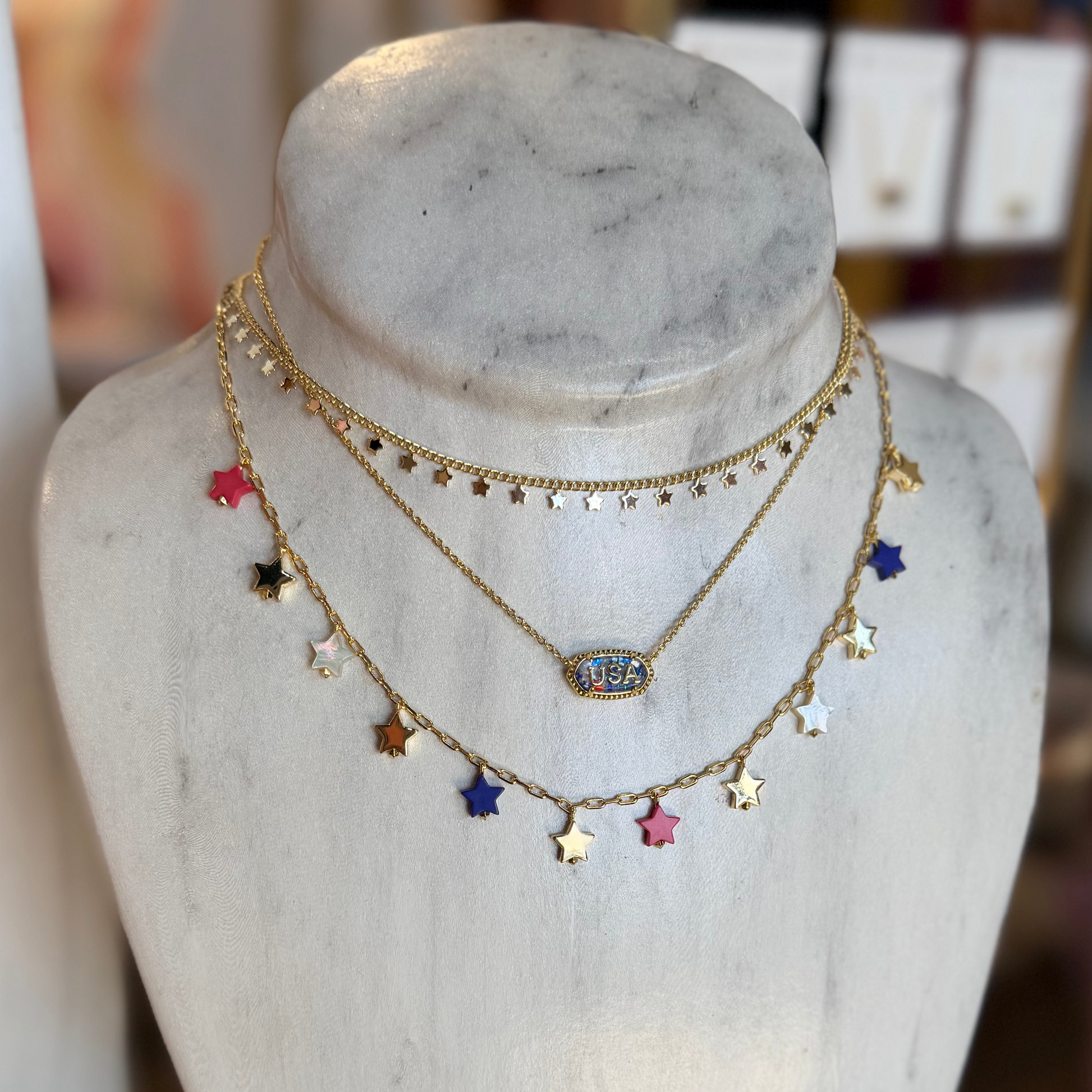 Necklace with colorful star pendants on a marble bust