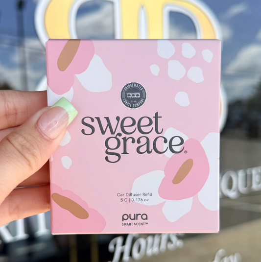 Hand holding a 'sweet grace' product packaging with a blurred store background