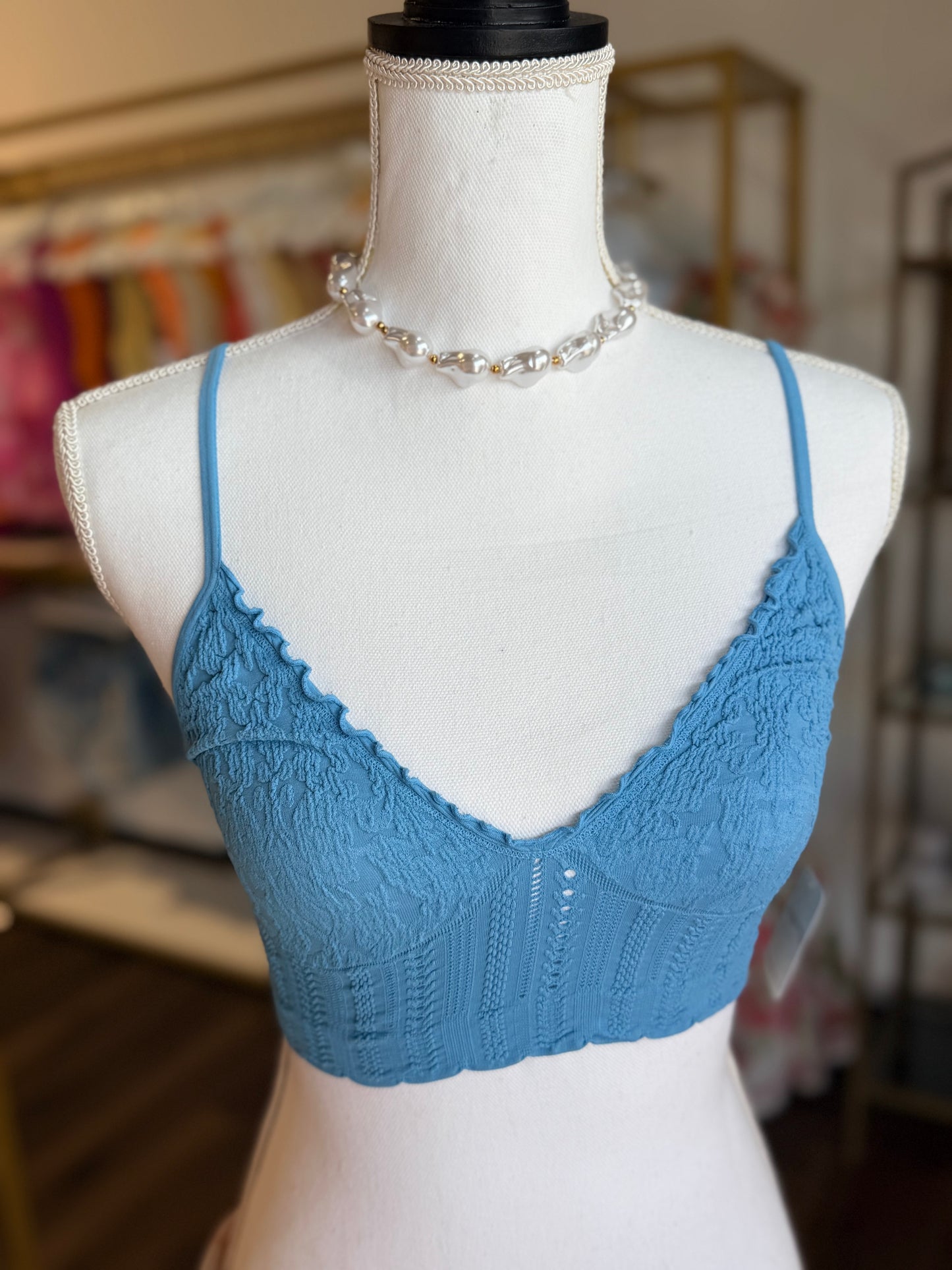 Blue lace bra on a mannequin with a blurred indoor background