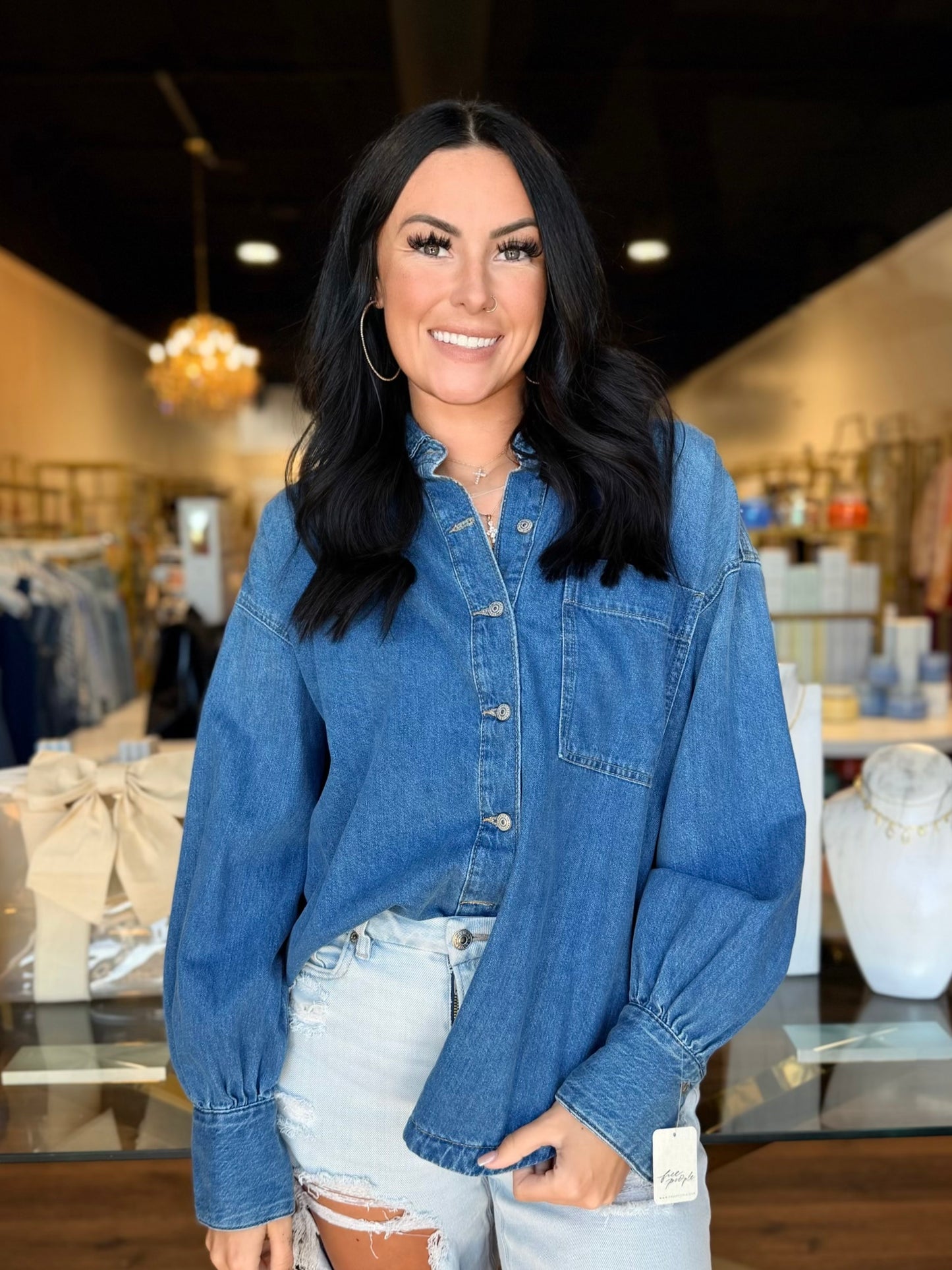 Model in front of store with Jean button up shirt on 