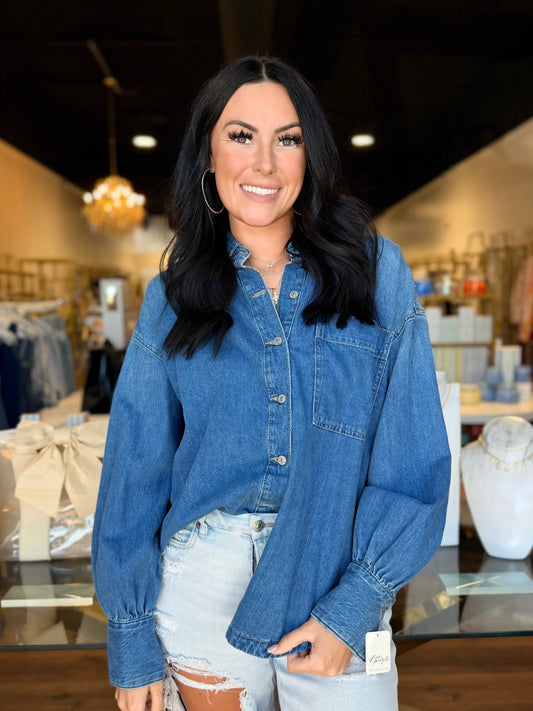 Model in front of store with Jean button up shirt on 