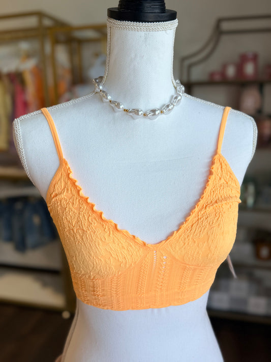 Orange lace bra on a mannequin with a blurred background