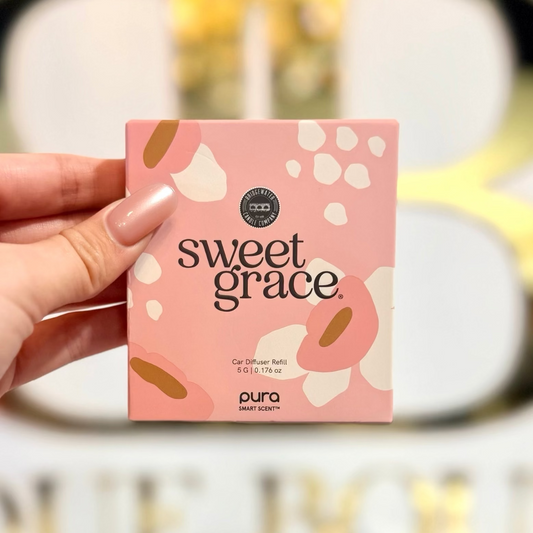 Hand holding a 'sweet grace' product packaging with a blurred background