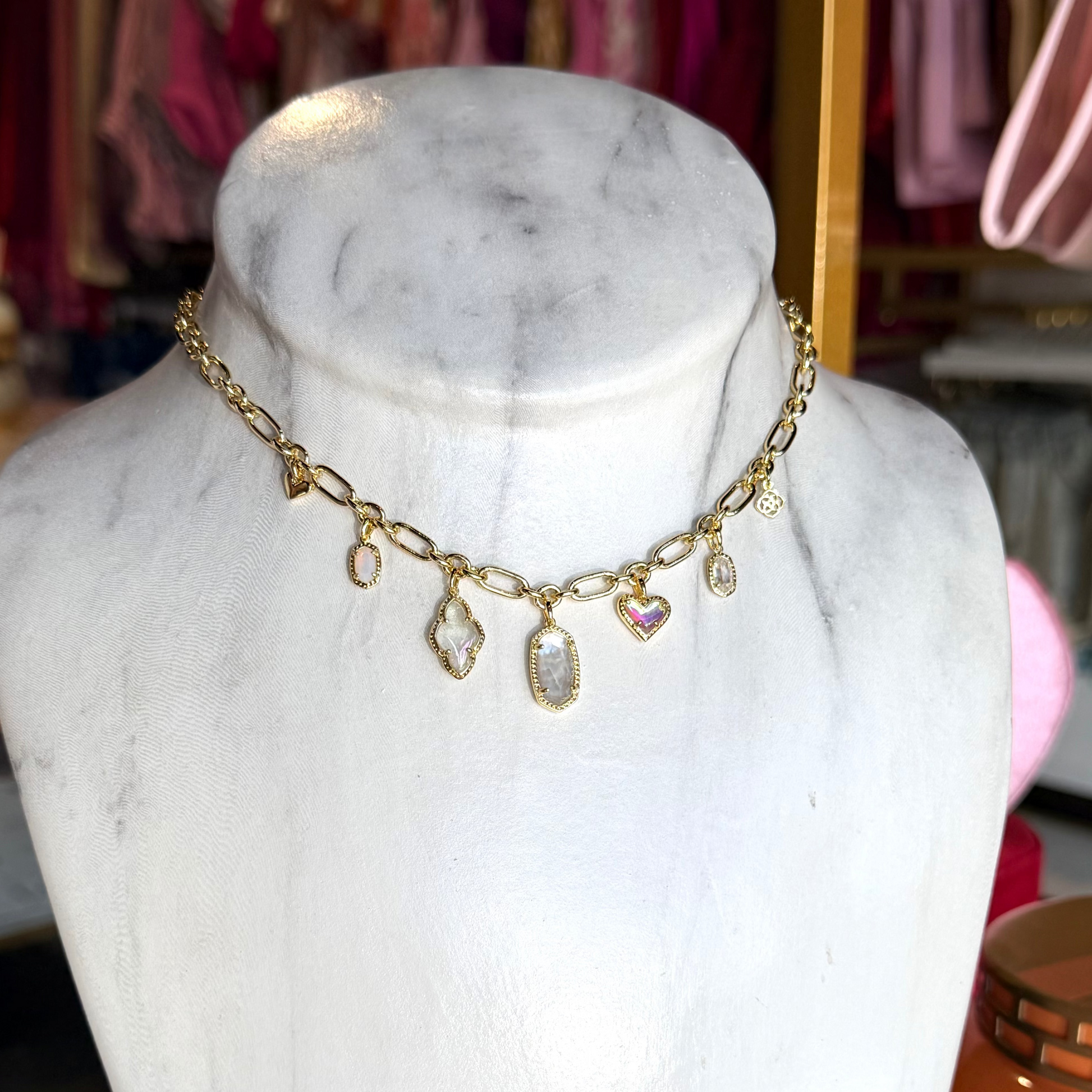 Gold necklace on a marble bust with a blurred store background