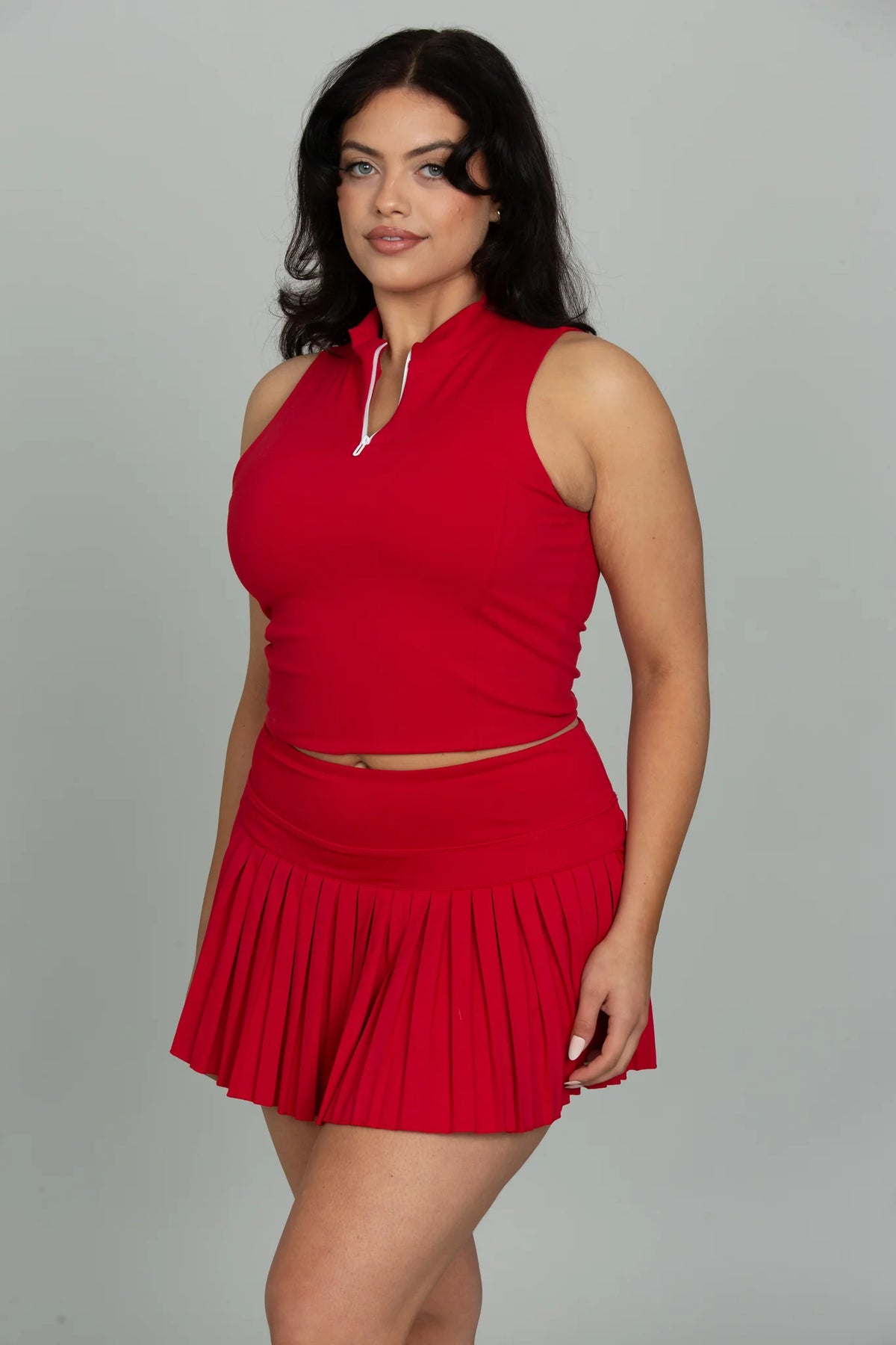 Coordinated outfit styled with the GOLD HINGE Pleated Tennis Skirt in Ruby