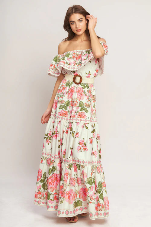 Woman wearing a floral off-shoulder dress on a plain background