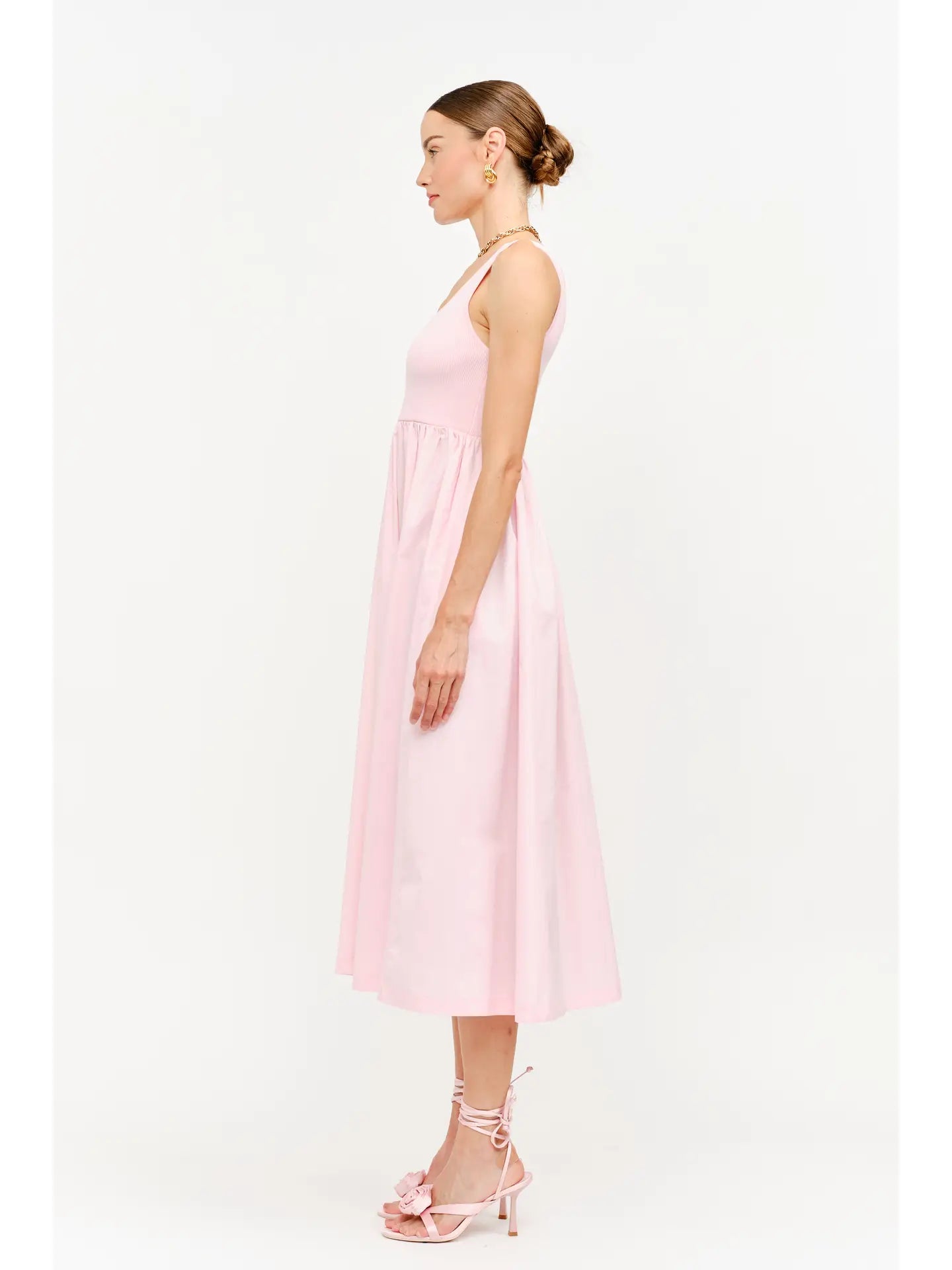 model wearing a pink maxi dress standing to the side 