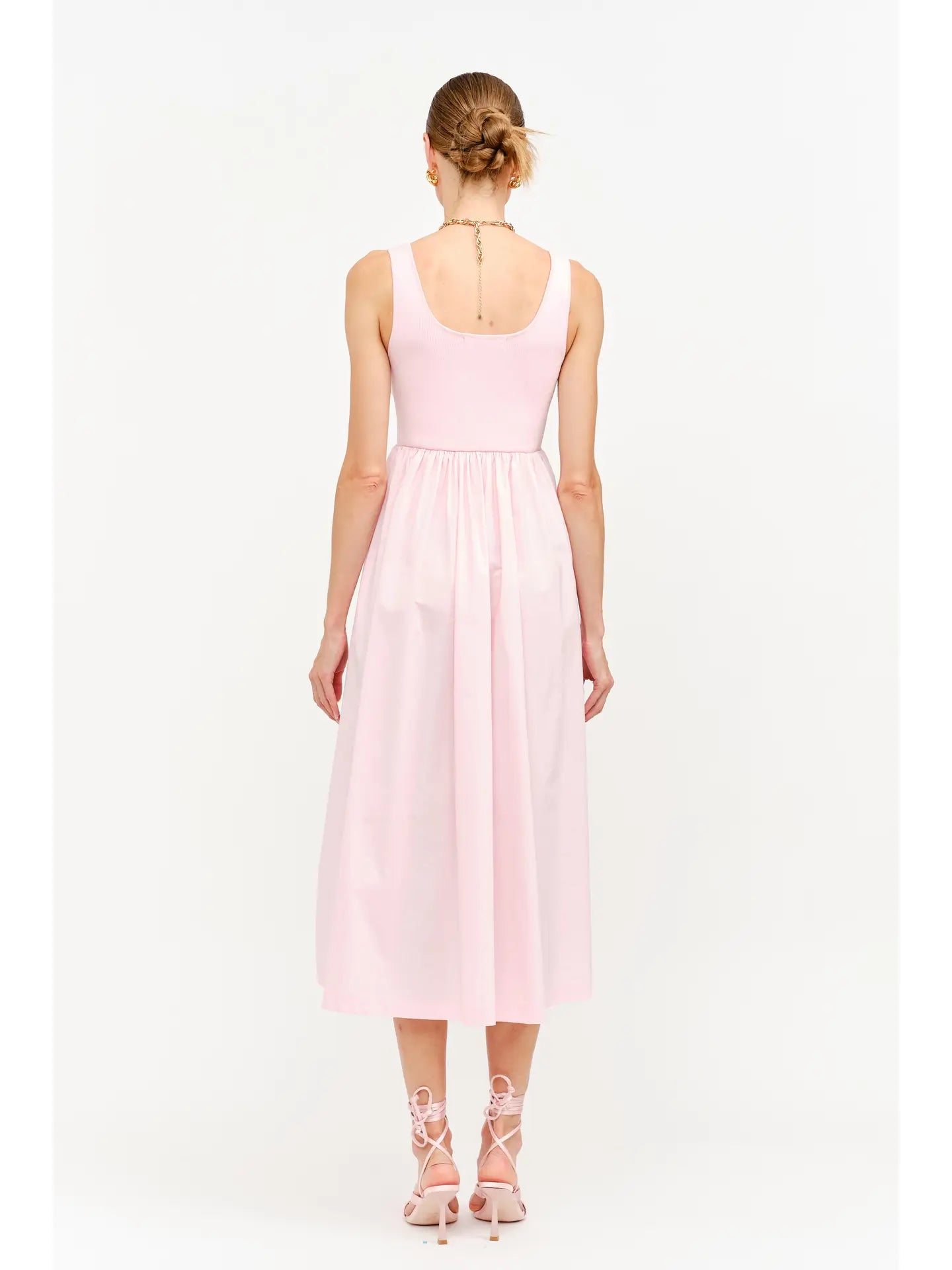 model wearing a pink maxi dress standing to the back