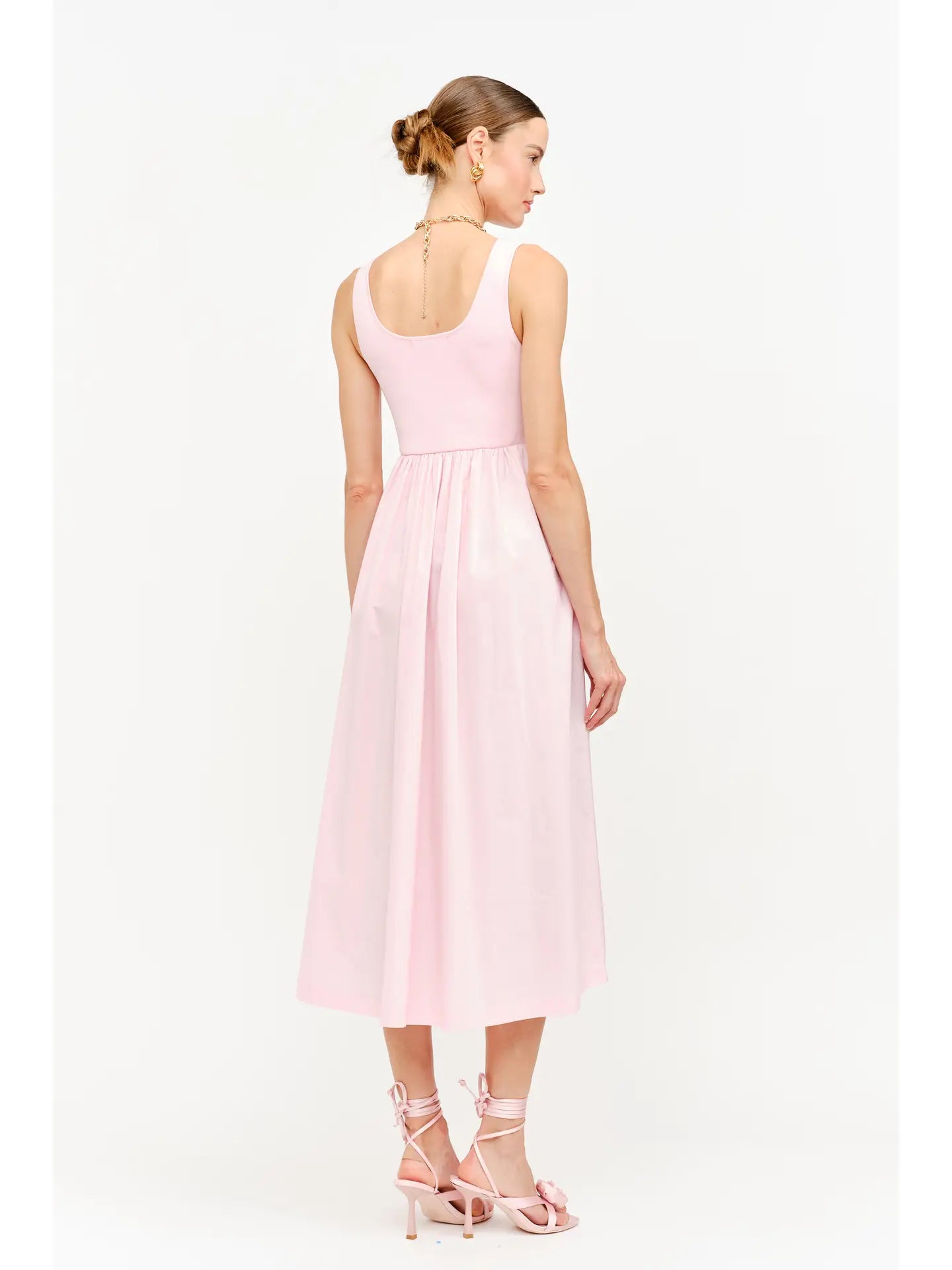model wearing a pink maxi dress standing to the back and side