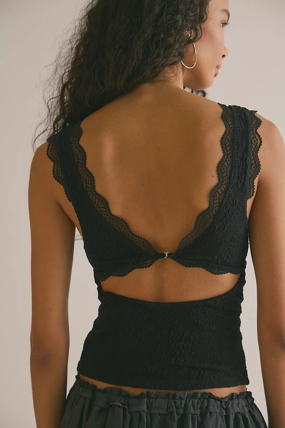 Model wearing black lace tank top facing backwards