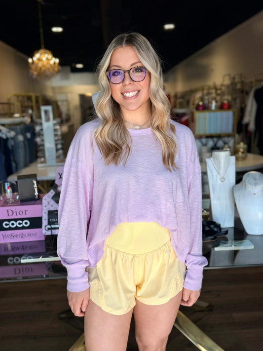 model wearing pink long sleeve top and yellow shorts