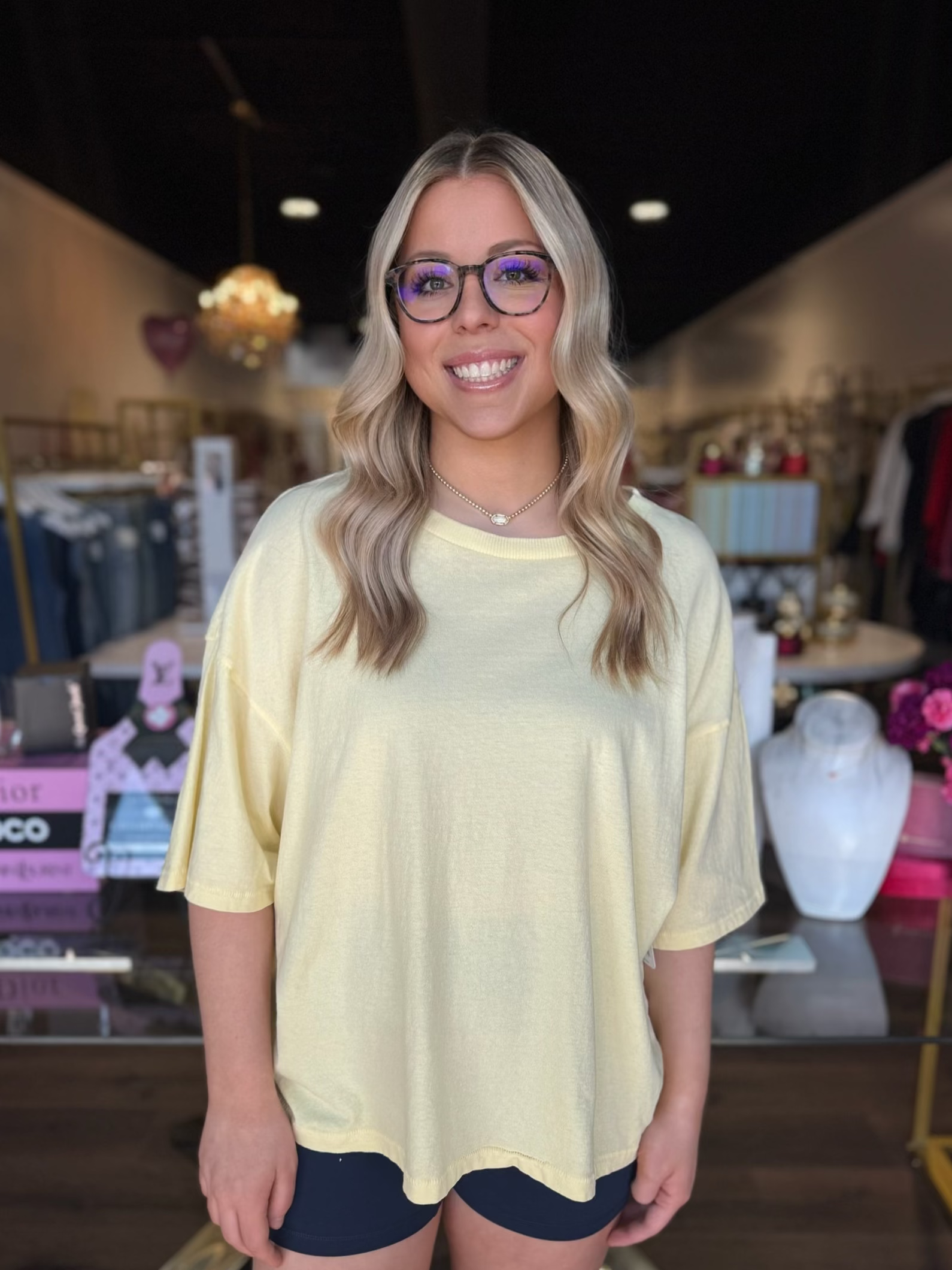 model wearing yellow top with navy blue biker shorts