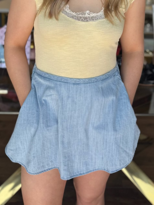 model wearing yellow top with lace trim and denim skirt 